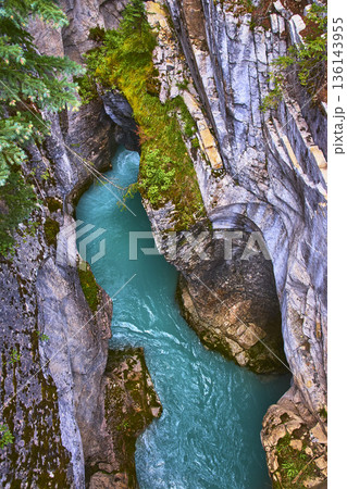 Aerial Turquoise River Flowing Through Rocky Canyon With Lush Green Vegetation 136143955