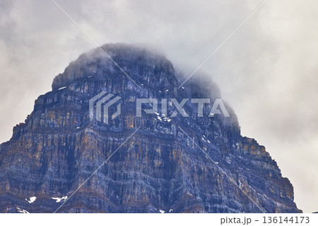 Misty Mountain Peak Close Up with Steep Rock Layers and Cloudy Sky Misty Mountain Peak Close Up with Steep Rock Layers and Cloudy Sky 136144173