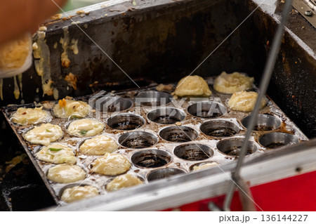Cooking Asian street food snacks in round metal mold pan for culinary concept 136144227
