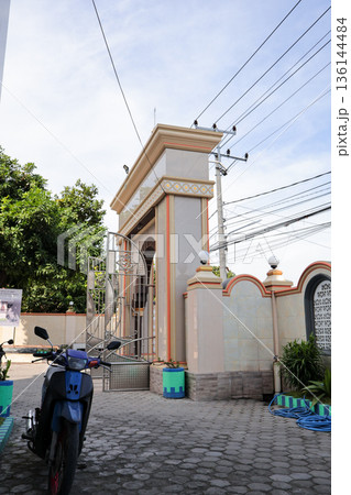 Entrance Gate to Building Under Natural Light with Architectural Detail and Clear Sky Backdrop for Travel and Cultural Heritage Concepts Entrance Gate to Building Under Natural Light with Architectural Detail and Clear Sky Backdrop for Travel and Cultural Heritage Concepts 136144484