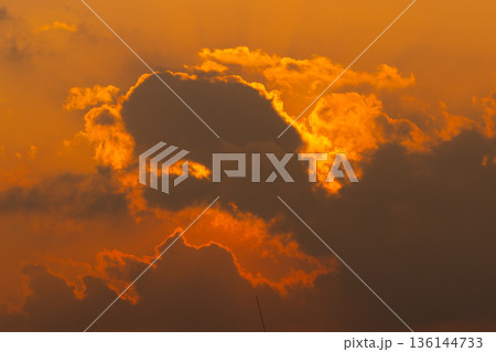 Sunset light shining through thick dark clouds Sunset light shining through thick dark clouds 136144733