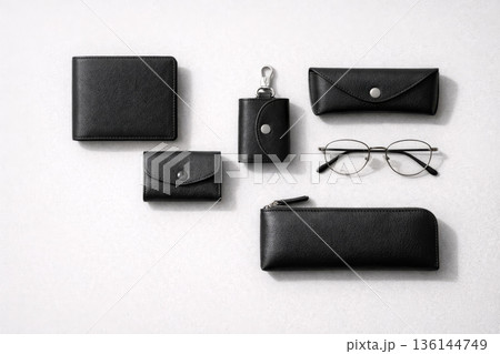 黒いレザー財布と革小物を揃えたミニマルなフラットレイ 136144749