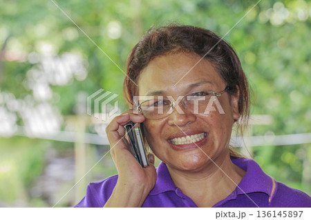 senior woman talking on mobile phone senior woman talking on mobile phone 136145897