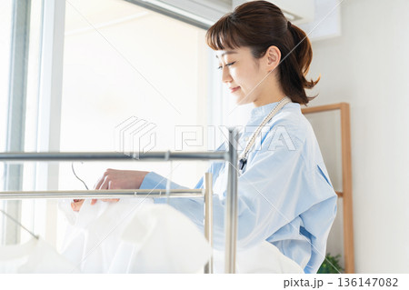 洗濯物を干す女性 136147082
