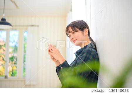 室内でスマホを見る女性 136148028