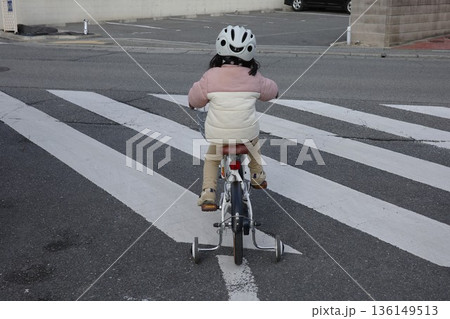 横断歩道で補助輪付きの自転車に乗る子ども 136149513