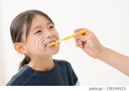 仕上げ磨きをしてもらう女の子 仕上げ磨きをしてもらう女の子 136149523