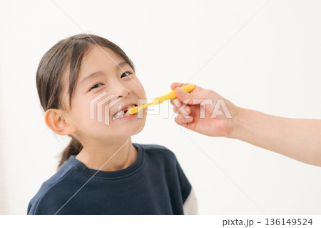 仕上げ磨きをしてもらう女の子 仕上げ磨きをしてもらう女の子 136149524