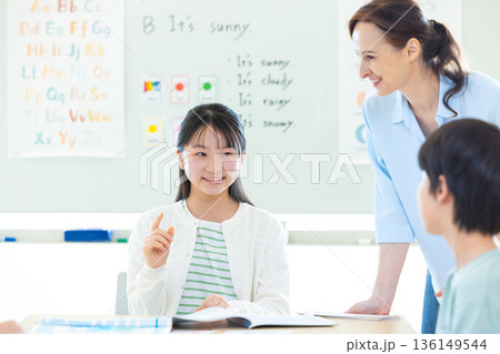 教育　英会話教室でレッスンを受ける子供とネイティブ講師 136149544