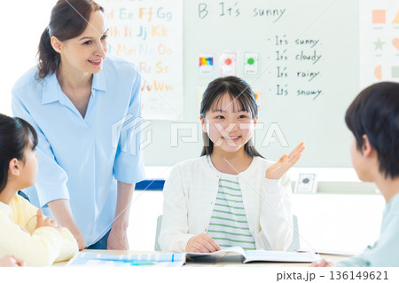 教育　英会話教室でレッスンを受ける子供とネイティブ講師 136149621