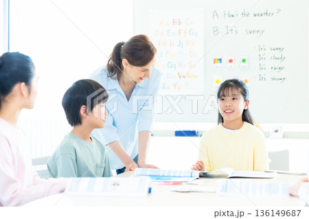 教育　英会話教室でレッスンを受ける子供とネイティブ講師 136149687