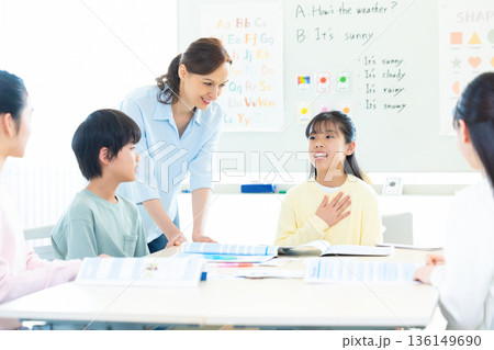 教育　英会話教室でレッスンを受ける子供とネイティブ講師 136149690