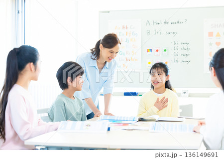 教育　英会話教室でレッスンを受ける子供とネイティブ講師 136149691