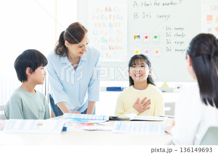 教育　英会話教室でレッスンを受ける子供とネイティブ講師 136149693