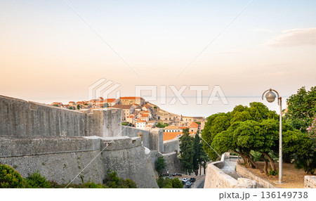 Panoramic view of sunrise over old town of Dubrovnik. Ancient city wall and Minceta tower. Famous tourist destination in Croatia. Summer morning, soft warm light. UNESCO heritage. Panoramic view of sunrise over old town of Dubrovnik. Ancient city wall and Minceta tower. Famous tourist destination in Croatia. Summer morning, soft warm light. UNESCO heritage. 136149738