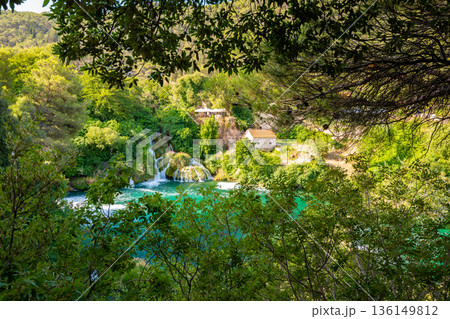 Waterfalls at Krka river, Croatia. Part of the Skradinski Buk waterfall. Famous place in nature park - beautiful tourist destination in Croatia. Fresh green nature, summer weather. Waterfalls at Krka river, Croatia. Part of the Skradinski Buk waterfall. Famous place in nature park - beautiful tourist destination in Croatia. Fresh green nature, summer weather. 136149812