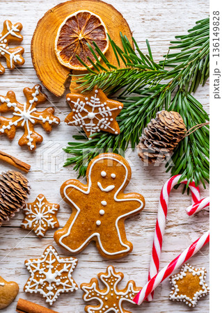 Christmas gingerbread and sweets are placed on wooden desk. Cookies and sweet food in shape of stars and snow flakes. Winter theme, rustic style. Pine trees on the side. Candy stick and other spice. Christmas gingerbread and sweets are placed on wooden desk. Cookies and sweet food in shape of stars and snow flakes. Winter theme, rustic style. Pine trees on the side. Candy stick and other spice. 136149828
