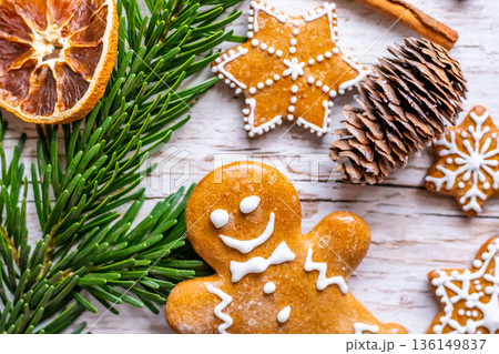Christmas gingerbread and sweets are placed on wooden desk. Cookies and sweet food in shape of stars and snow flakes. Winter theme, rustic style. Pine trees on the side. Candy stick and other spice. Christmas gingerbread and sweets are placed on wooden desk. Cookies and sweet food in shape of stars and snow flakes. Winter theme, rustic style. Pine trees on the side. Candy stick and other spice. 136149837