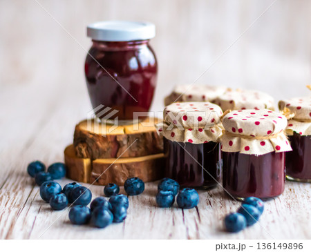 Blueberry jam placed in small glasses on wooden desk. Fresh blueberries around. Homemade marmalade, concept of healthy cooking. 136149896