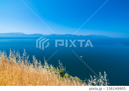 View of beautiful Croatia coast near Makarska. Blue sea with white beach. Isles in the background. Summer weather, blue sky. View of beautiful Croatia coast near Makarska. Blue sea with white beach. Isles in the background. Summer weather, blue sky. 136149905