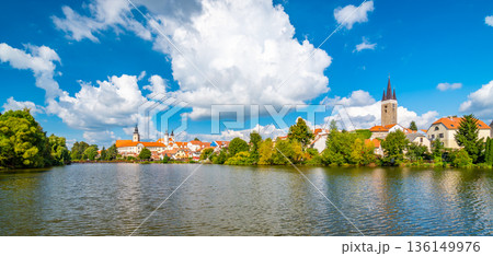 Panorama view of Telc city, Czech Republic. Historical castle above the lake. UNESCO heritage. Summer day, blue sky with clouds. Panorama view of Telc city, Czech Republic. Historical castle above the lake. UNESCO heritage. Summer day, blue sky with clouds. 136149976