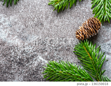 Pine cone is placed on gray background with green pine tree branch. Winter and christmas decoration. Pine cone is placed on gray background with green pine tree branch. Winter and christmas decoration. 136150018