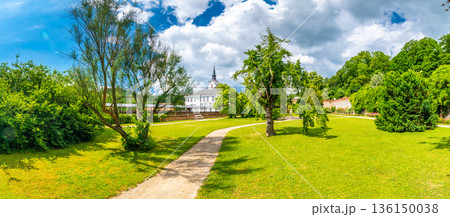 Lysice castle, Czech Republic. Famous baroque castle built in 14th century. Beautiful formal garden, palm trees and flowers. Promenade near the castle. Sunny day, dramatic clouds before storm. Lysice castle, Czech Republic. Famous baroque castle built in 14th century. Beautiful formal garden, palm trees and flowers. Promenade near the castle. Sunny day, dramatic clouds before storm. 136150038
