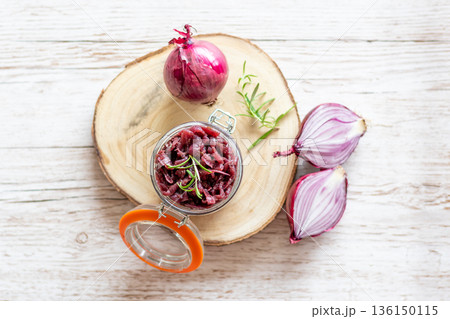 Red onion marmalade placed on wooden trunk with wood texture background. Jam from onion is delicious part of French cuisine. Homemade jam in transparent glass, vibrant colors, soft light. Red onion marmalade placed on wooden trunk with wood texture background. Jam from onion is delicious part of French cuisine. Homemade jam in transparent glass, vibrant colors, soft light. 136150115