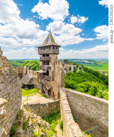 Panorama view of medieval castle Helfstyn, Czech Republic. Detail of tower with stone walls at ancient fortress. Sunny day, blue sky with clouds. Panorama view of medieval castle Helfstyn, Czech Republic. Detail of tower with stone walls at ancient fortress. Sunny day, blue sky with clouds. 136150283