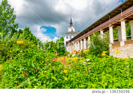 Lysice castle, Czech Republic. Famous baroque castle built in 14th century. Beautiful formal garden, palm trees and flowers. Promenade near the castle. Sunny day, dramatic clouds before storm. 136150298