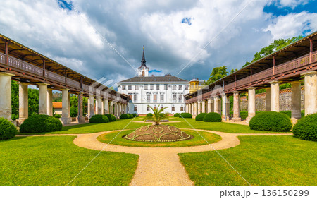 Lysice castle, Czech Republic. Famous baroque castle built in 14th century. Beautiful formal garden, palm trees and flowers. Promenade near the castle. Sunny day, dramatic clouds before storm. Lysice castle, Czech Republic. Famous baroque castle built in 14th century. Beautiful formal garden, palm trees and flowers. Promenade near the castle. Sunny day, dramatic clouds before storm. 136150299