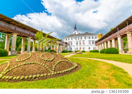Lysice castle, Czech Republic. Famous baroque castle built in 14th century. Beautiful formal garden, palm trees and flowers. Promenade near the castle. Sunny day, dramatic clouds before storm. Lysice castle, Czech Republic. Famous baroque castle built in 14th century. Beautiful formal garden, palm trees and flowers. Promenade near the castle. Sunny day, dramatic clouds before storm. 136150300