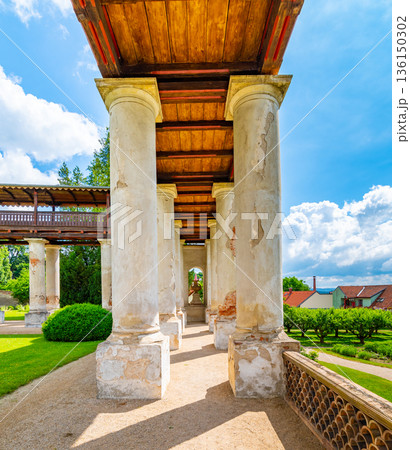 Lysice castle, Czech Republic. Famous baroque castle built in 14th century. Beautiful formal garden, palm trees and flowers. Promenade near the castle. Sunny day, dramatic clouds before storm. 136150302