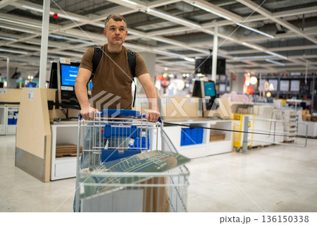 Man shopping with cart in store 136150338