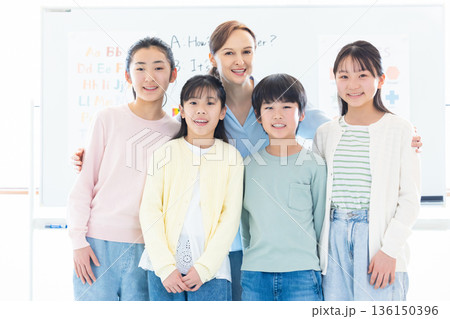 教育　英会話教室でレッスンを受ける子供とネイティブ講師のポートレート 136150396