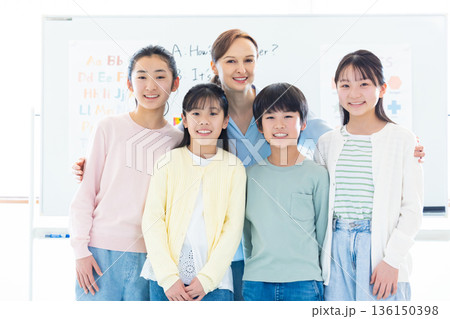 教育　英会話教室でレッスンを受ける子供とネイティブ講師のポートレート 136150398