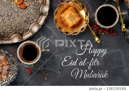 Celebration of Eid al-Fitr with coffee, sweets, and traditional treats on a serving table 136150589