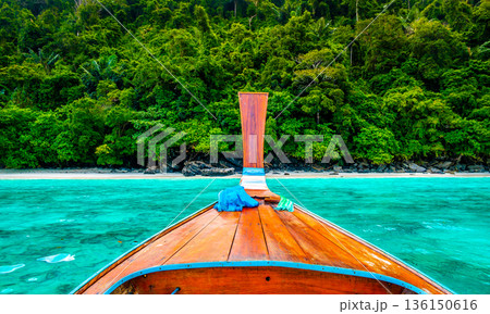 View of monkey beach at Ko Phi Phi islands, Thailand. Famous tropical beach with white sand and turquoise water. View from long tail boat. Summer paradise. View of monkey beach at Ko Phi Phi islands, Thailand. Famous tropical beach with white sand and turquoise water. View from long tail boat. Summer paradise. 136150616