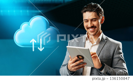 Man using tablet for cloud computing with blue background in an office setting 136150847