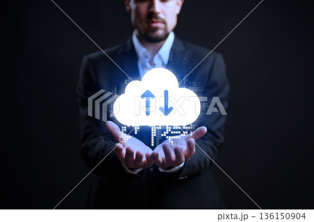 Man holds cloud icon with arrows in dark space showing data management at night 136150904