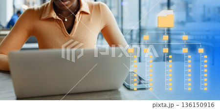 Person works on laptop with folder structure diagram in a modern setting Person works on laptop with folder structure diagram in a modern setting 136150916