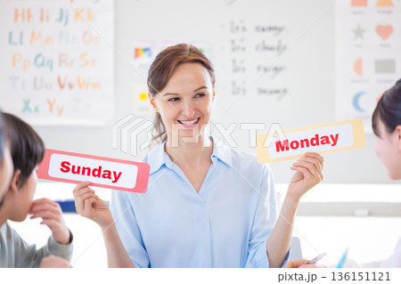 教育　英会話教室でレッスンを受ける子供とネイティブ講師 136151121
