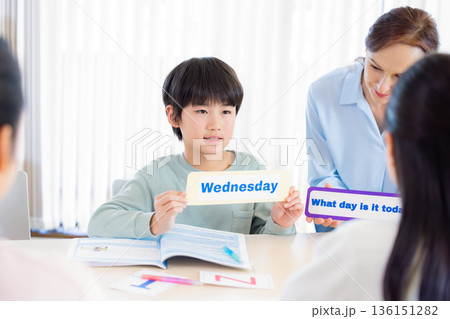 教育　英会話教室でレッスンを受ける子供とネイティブ講師 136151282