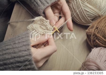 輪針で毛糸を編んでいる手元の写真　編み物　毛糸玉　メリヤス編み　趣味 136153305
