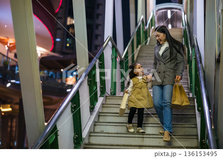 happy mother and child girl with shopping bag enjoying and walking down footbridge stairs in bangkok city at night happy mother and child girl with shopping bag enjoying and walking down footbridge stairs in bangkok city at night 136153495