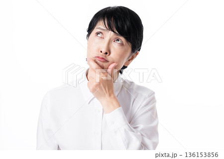 顎に手をあて考えるショートヘアーの中年女性 136153856