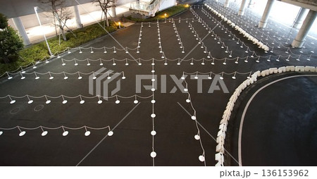 夜に俯瞰した待機エリアに並ぶ、規則正しい誘導ポールとチェーン 夜に俯瞰した待機エリアに並ぶ、規則正しい誘導ポールとチェーン 136153962