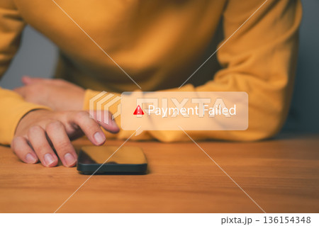 Close-up of hand using smartphone with Payment Failed alert message, representing online transaction error, declined payment, banking problem, or digital finance security issue in mobile app. 136154348