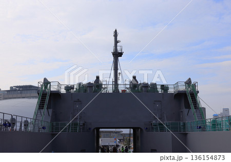 高松港に寄港した自衛隊の輸送艦「にほんばれ」の中央甲板から穴吹アリーナ香川のドーム屋根を見る 136154873