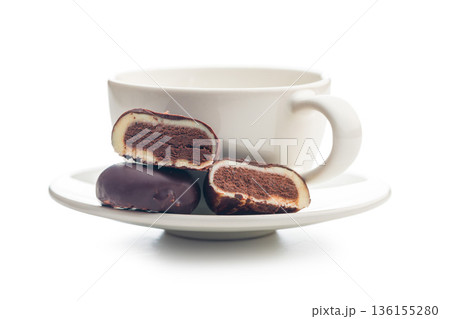 Dark chocolate truffles in the shape of coffee beans and coffee cup isolated on white background. Dark chocolate truffles in the shape of coffee beans and coffee cup isolated on white background. 136155280
